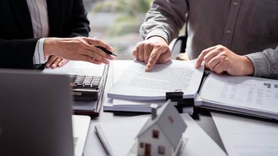 A real estate agent and residential seller going through the essential documents needed for a home sale in Barbados.